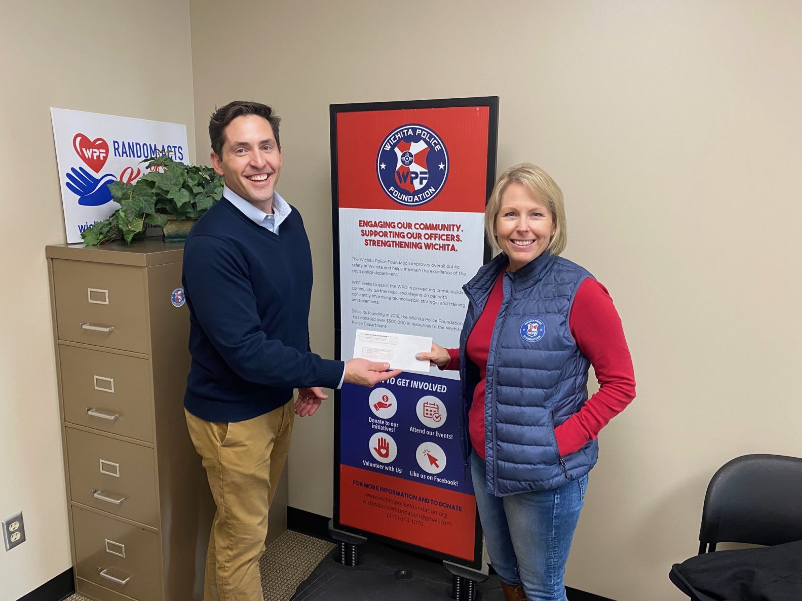 Mitch Binns, McCownGordon Market Leader hands donation check to Jennifer Clark, Executive Director of Wichita Police Foundation