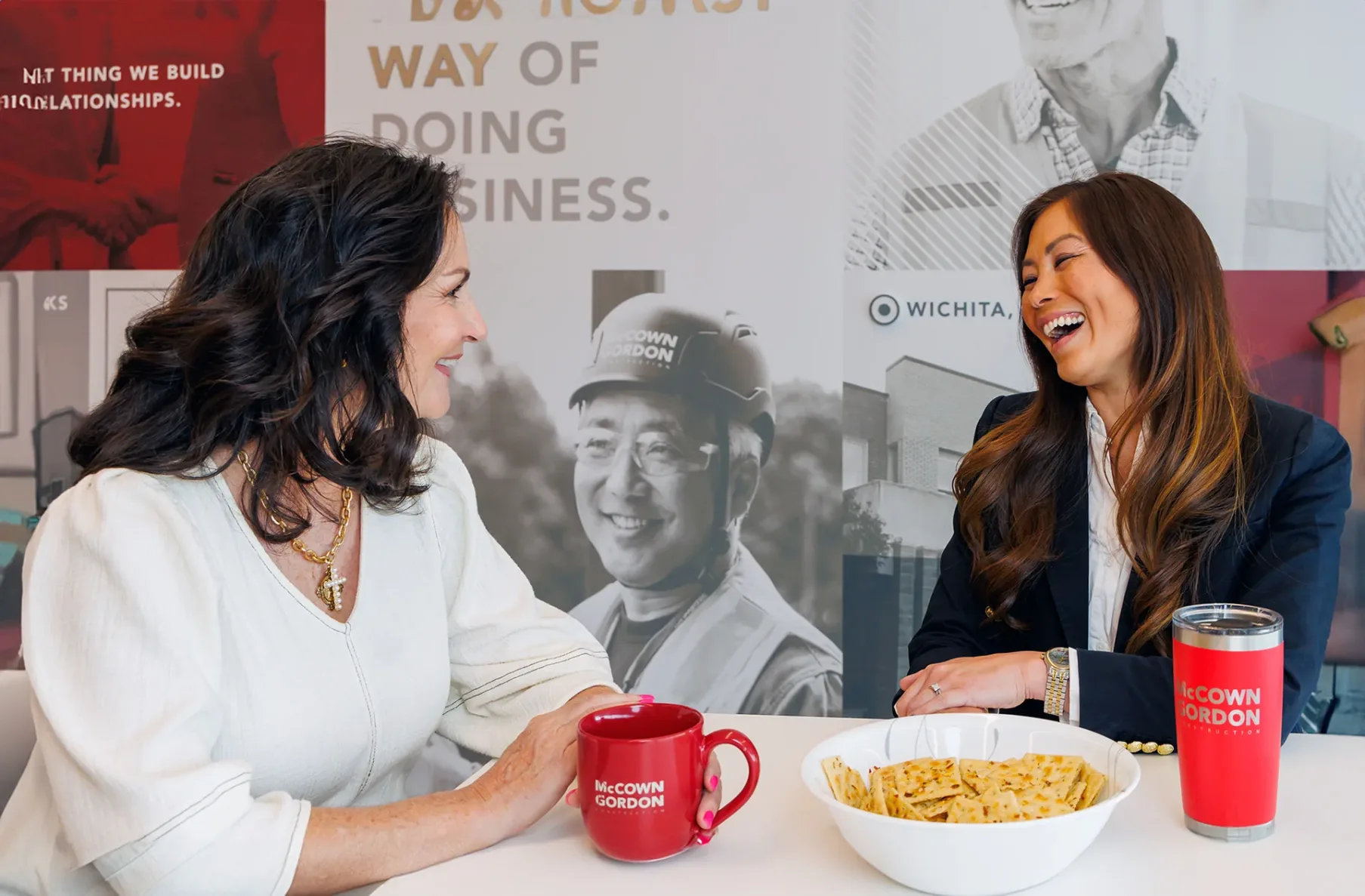 Two women laughing and having a snack in the McCownGordon office.