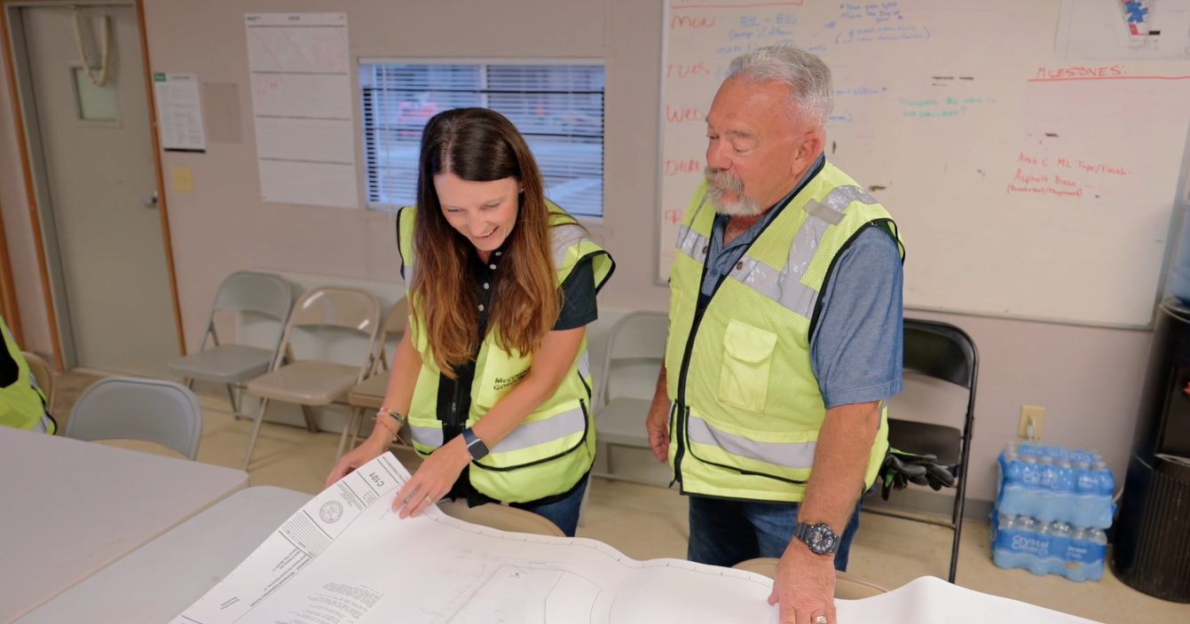 Two McCownGordon associates looking at construction and design drawings in a job trailer